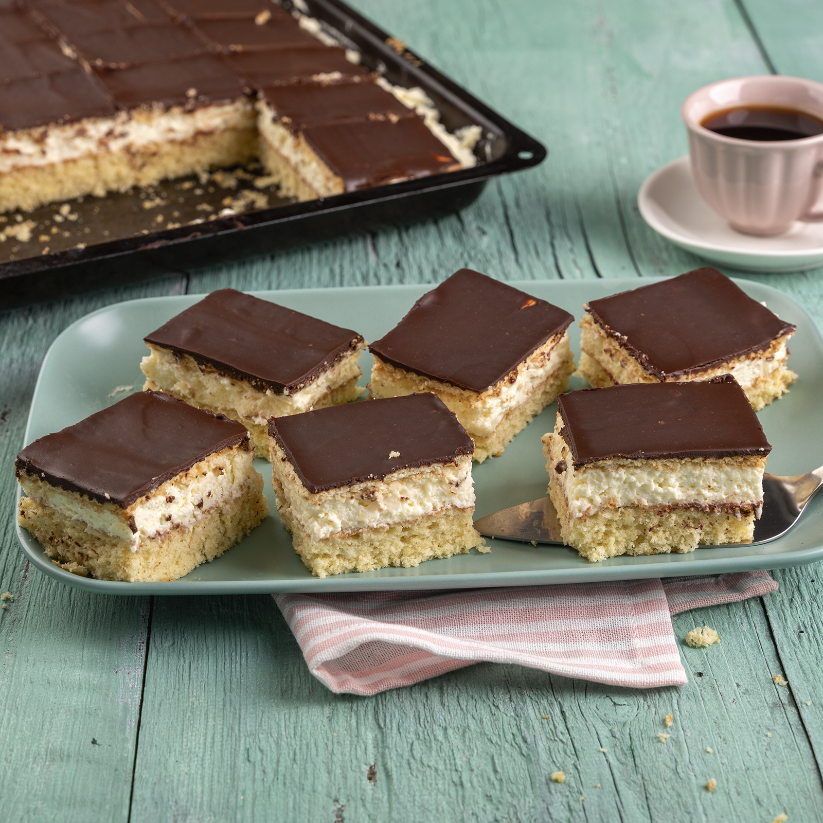 Butterkeksschnitten vom Blech mit Zitronencreme und Schokoladenglasur, angerichtet auf einer Servierplatte.