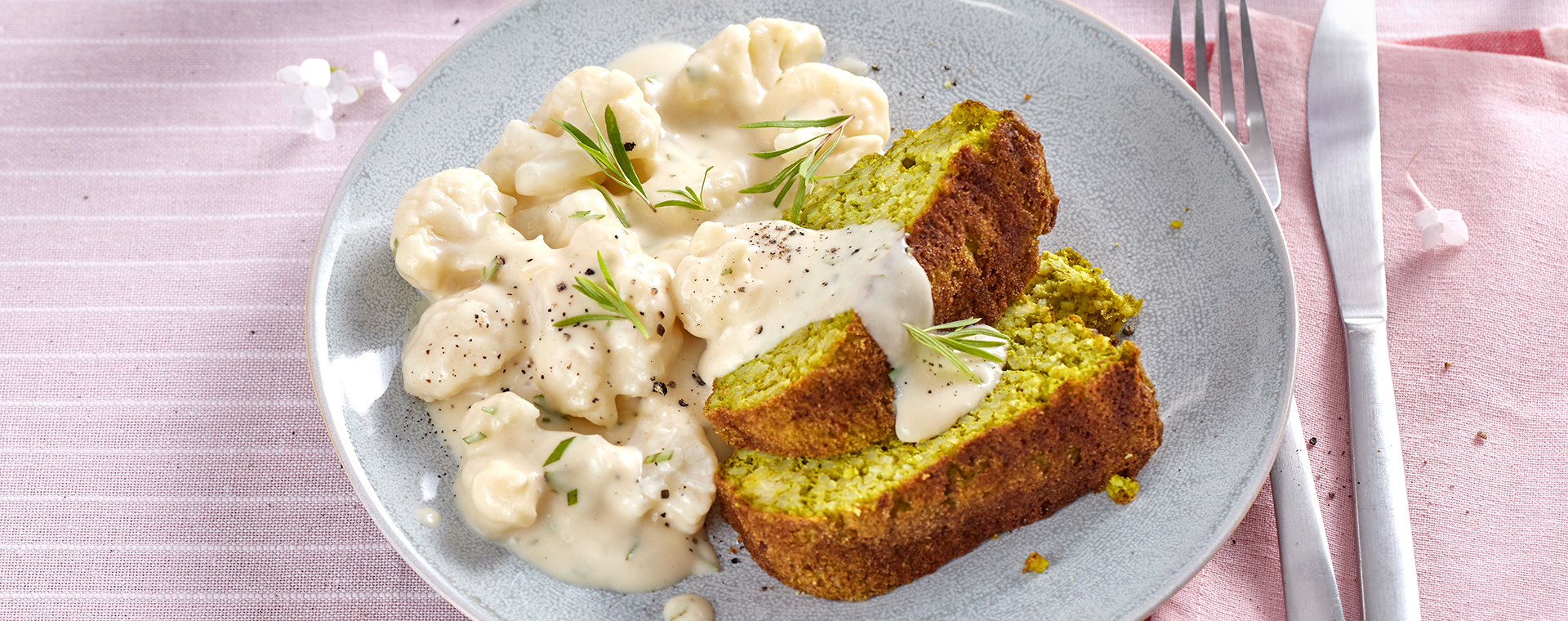 Grüner Hirsegugelhupf mit Blumenkohl in Estragon-Sahnesoße auf einem Teller.