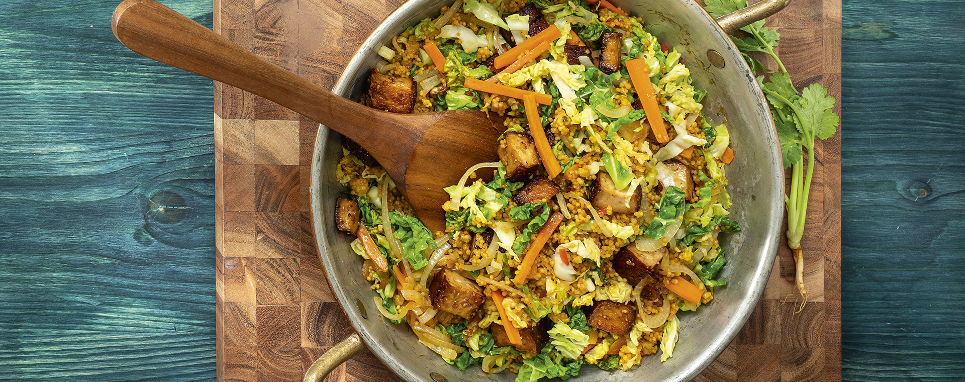 Veganer Hirse-Wok mit Wirsing, Möhren und Tofu.