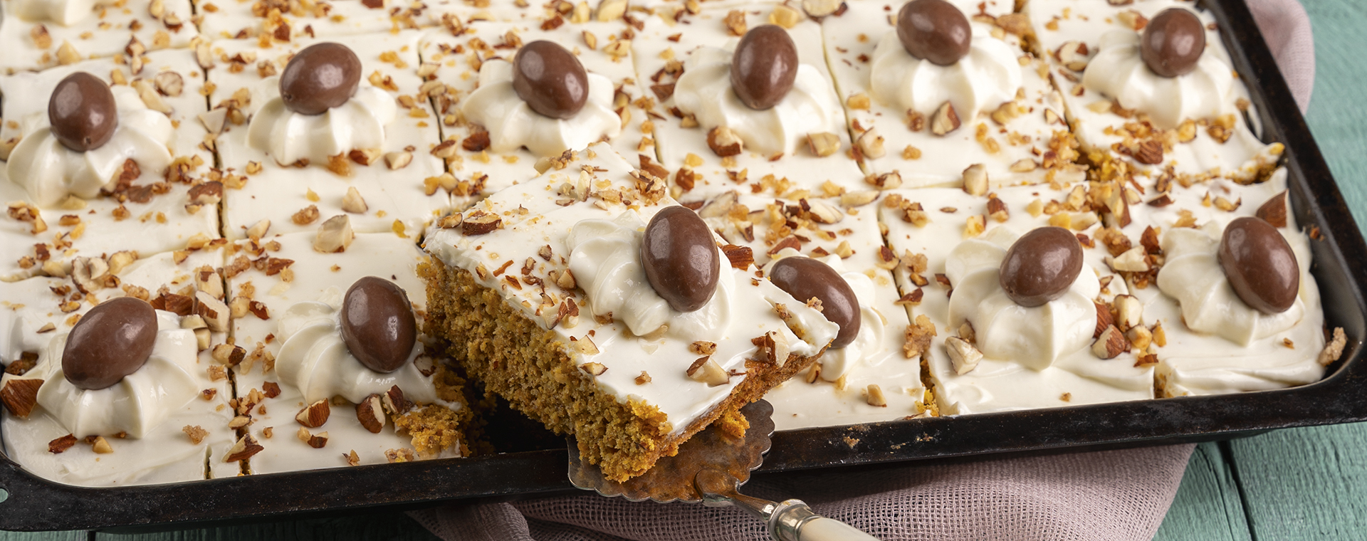 Möhrenkuchen vom Blech mit Frischkäsecreme, Mandelkrokant und Schokoladeneiern.