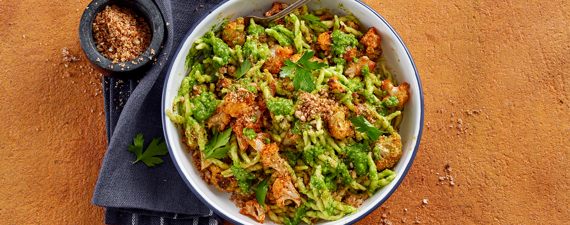 Trofie mit Petersilienpesto und Röstblumenkohl, angerichtet auf einem Teller.
