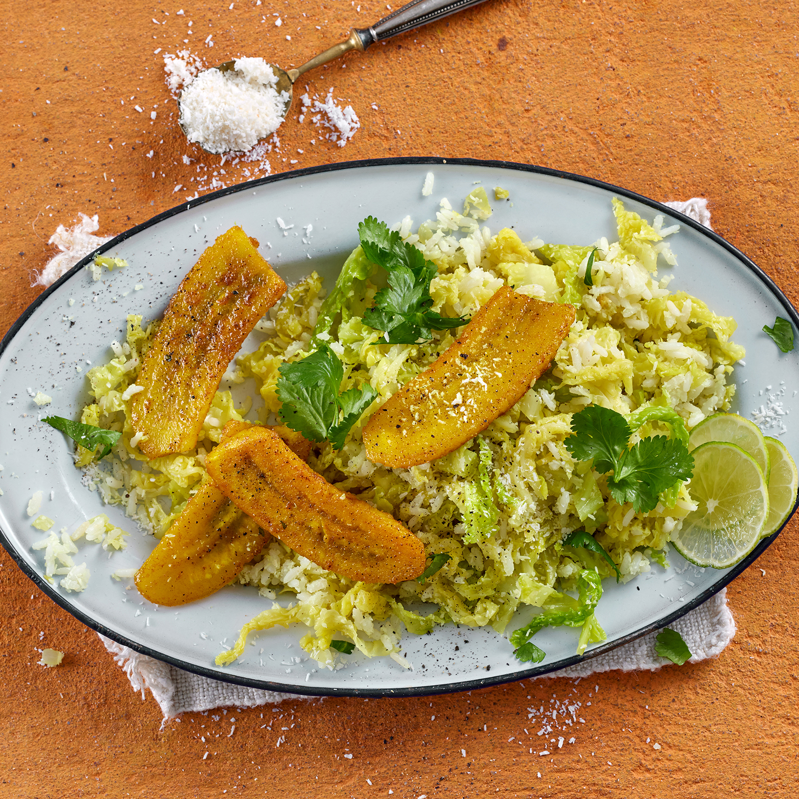 Wirsing-Kokos-Reis mit Currybananen und Koriander auf einem Teller.